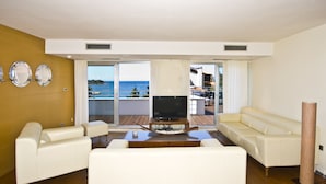 A living room with a TV, white sofas, and a wooden coffee table. - Villa Feniks (Medulin)
