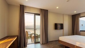 A modern hotel room with a large bed, a desk, a TV, and a balcony with a view. - Aria Butik Otel (Marmaris)