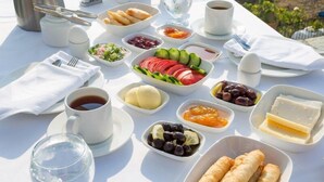 A table set with a variety of breakfast items including eggs, bread, fruits, and beverages. - Aria Butik Otel (Marmaris)