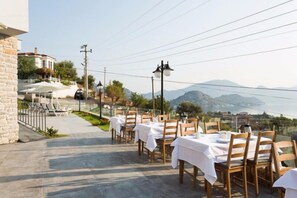 An outdoor dining area with tables set for two, overlooking a mountainous landscape. - Aria Butik Otel (Marmaris)