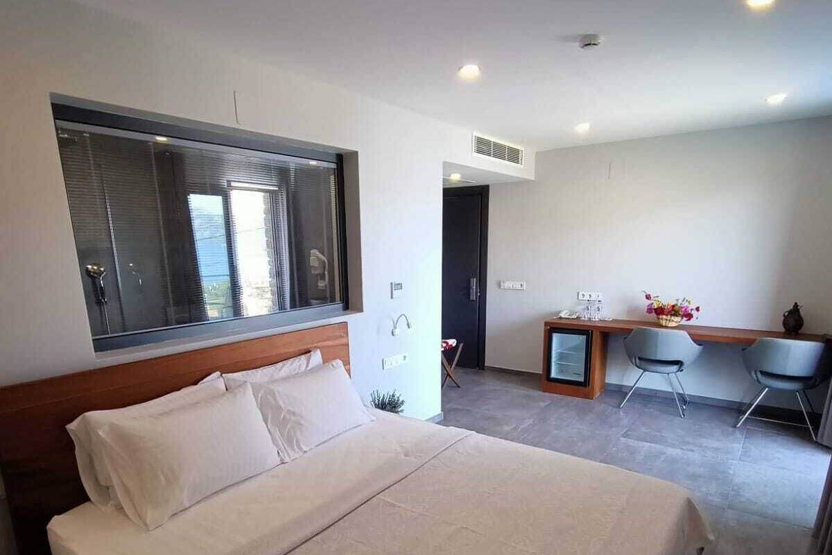 Ein modernes Hotelzimmer mit einem großen Bett, einem Schreibtisch und einem Sessel.