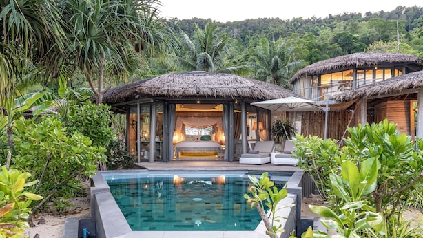 A resort with a pool, thatched-roof structures, and lush greenery. - TreeHouse Villas Koh Yao - Adults Only (Ko Yao)
