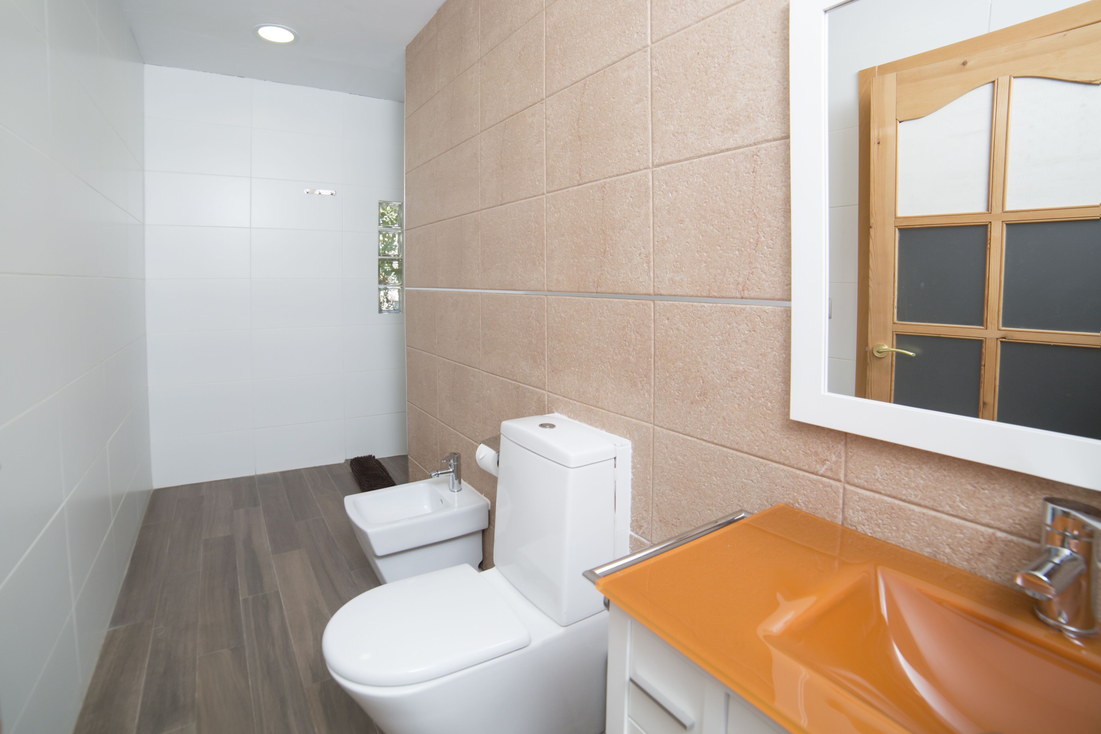 Un baño con inodoro, lavabo y espejo.