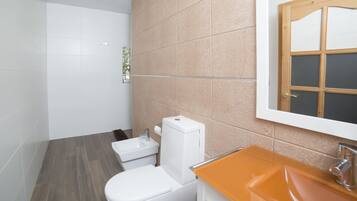 Un baño con inodoro, lavabo y espejo.