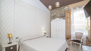A bedroom with a bed, nightstands, a wardrobe, a chair, and a balcony with a view. - L'Otelet by Sweet (Valencia)