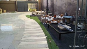 A paved pathway leading to a garden area with a variety of stones and pots. - L'Otelet by Sweet (Valencia)