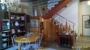 A dining area with a wooden table and chairs, a chandelier, and a staircase. - L'Otelet by Sweet (Valencia)