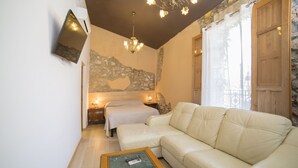A cozy living room with a leather sofa, a small wooden coffee table, and a stone accent wall. - L'Otelet by Sweet (Valencia)