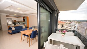 A modern apartment with a balcony, a dining area, and a kitchen.
