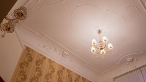 Et loft med en lysekrone og detaljeret stuk.
