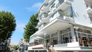 Un hotel de varios pisos con balcones, ventanas amplias y zonas de estar al aire libre.