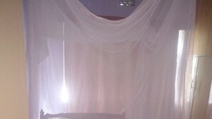 A room with a bed under a white canopy. - Hudsons Guest House (Nakuru)