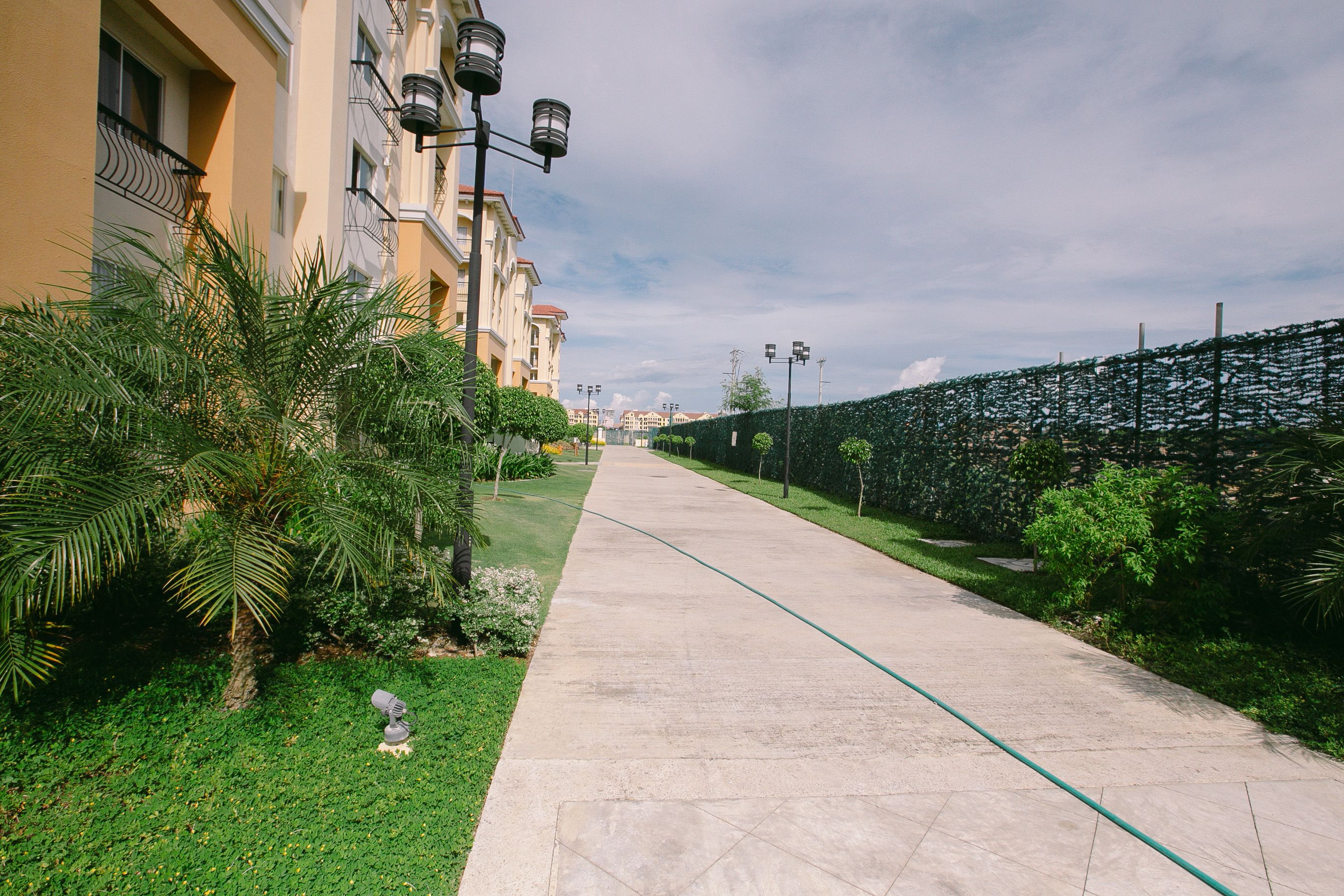 Un chemin pavé bordé de verdure et de bâtiments.