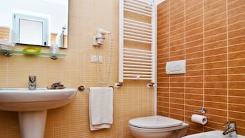 Casa de banho com lavatório, sanita e porta-toalhas.