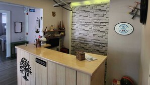 Una recepción con encimera de madera, una caja fuerte en la pared y un cartel con la inscripción 'RESPECTIVION'.