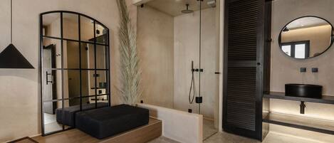A modern bathroom with a glass-enclosed shower, a black-framed mirror, and a minimalist design.