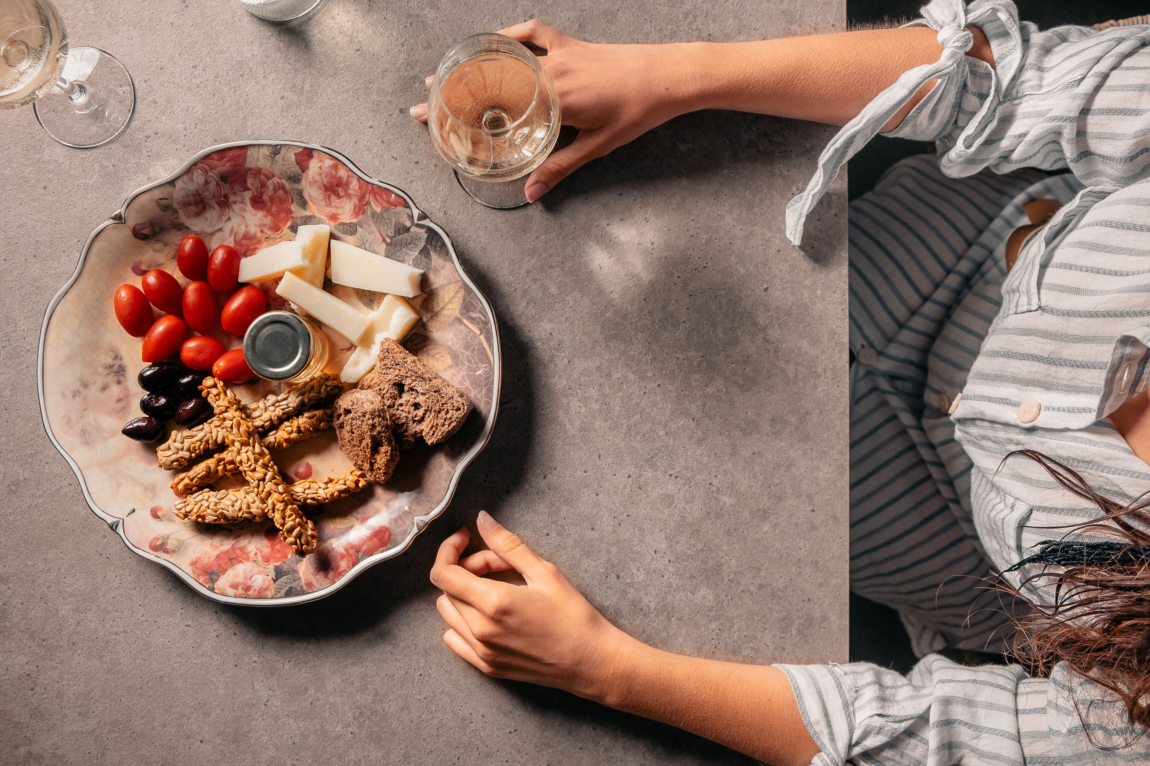 Une assiette contenant du fromage, des tomates, des olives et des crackers, posée sur une table.