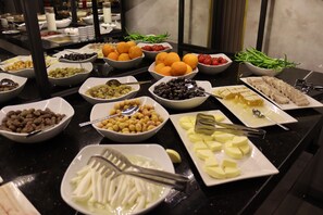 Un buffet proposant une variété d’aliments, notamment des fruits, des légumes et des fromages.