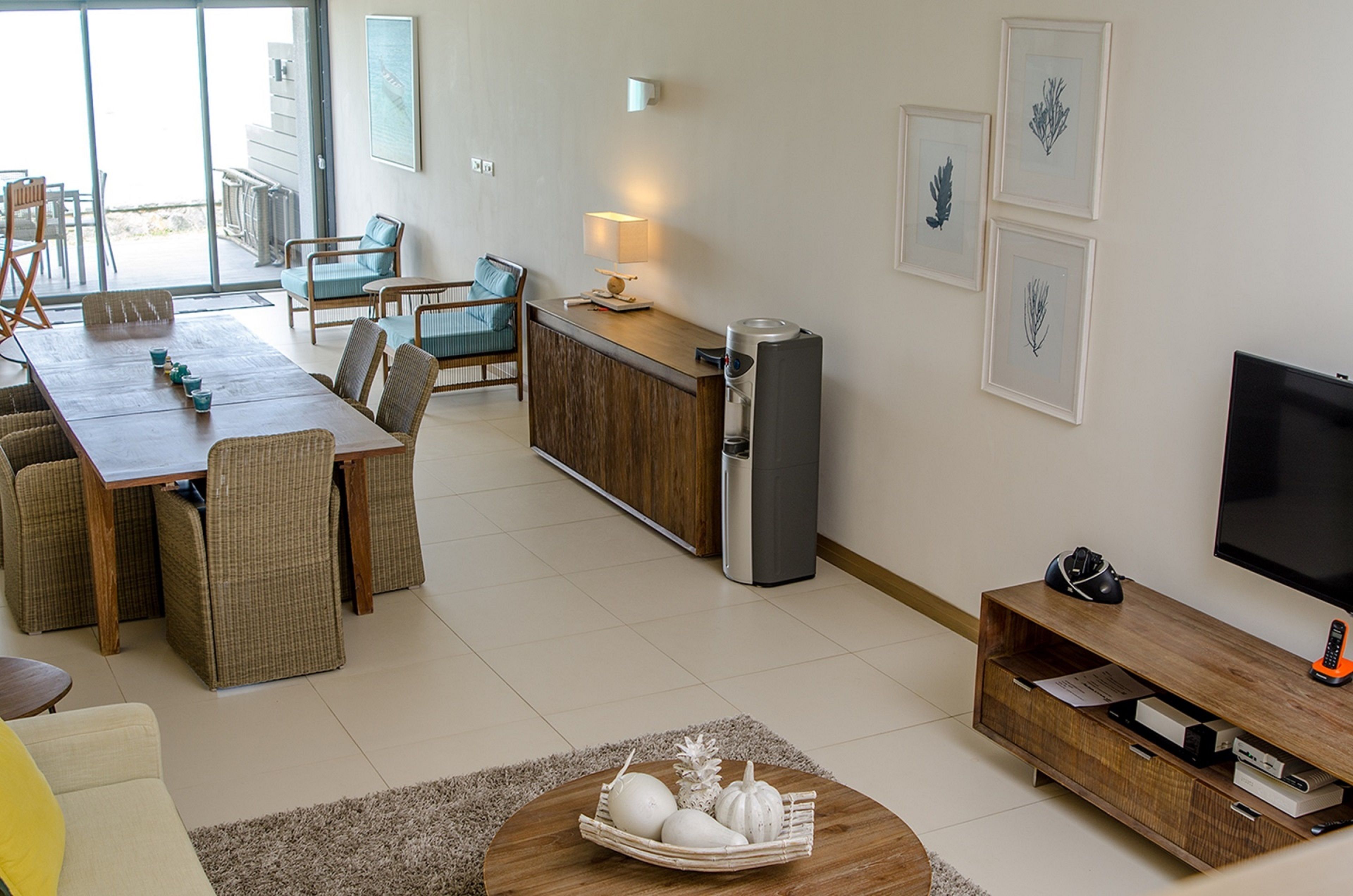 Una sala moderna con comedor, cocina y televisor.