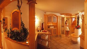 A hotel lobby with a reception desk, a seating area, and a staircase leading to the upper floors.