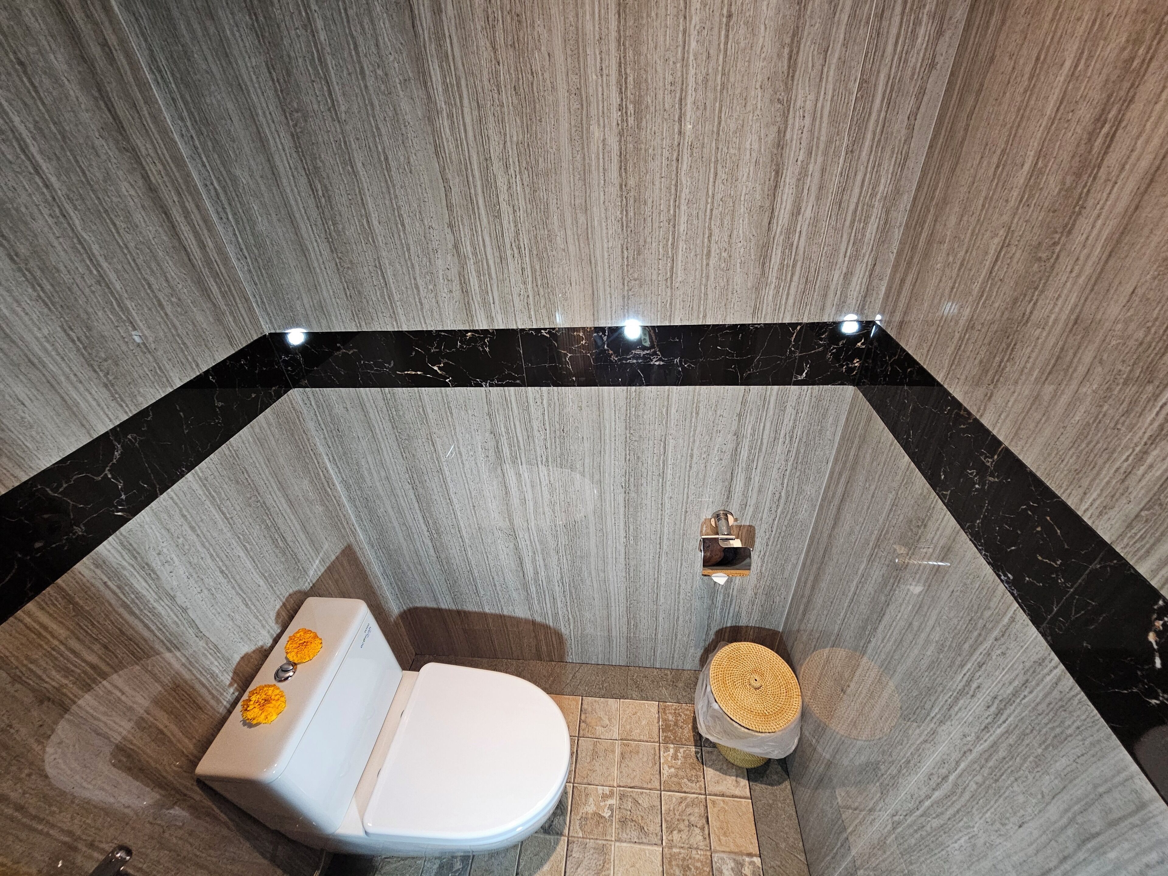 A bathroom with a toilet, bidet, and a small trash bin.