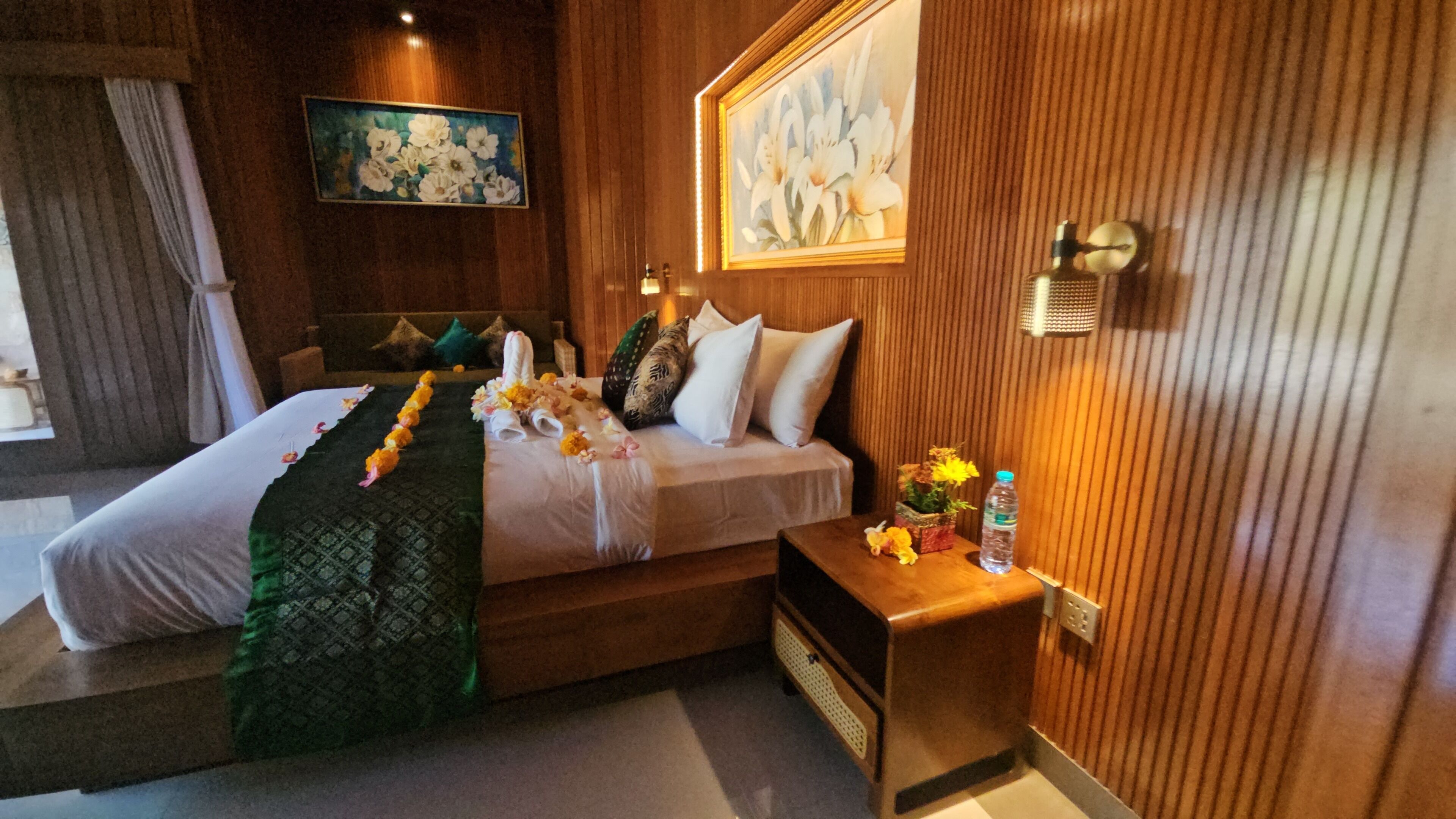 Une chambre d’hôtel avec un lit, une table de chevet, une lampe fixée au mur et un tableau.