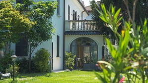 A two-story house with a balcony, a garden, and a large arched entrance. - Villa Franca in Franciacorta (Passirano)