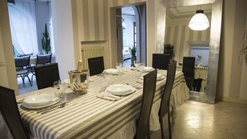 Un coin repas avec une nappe à rayures, une table dressée et des chaises.