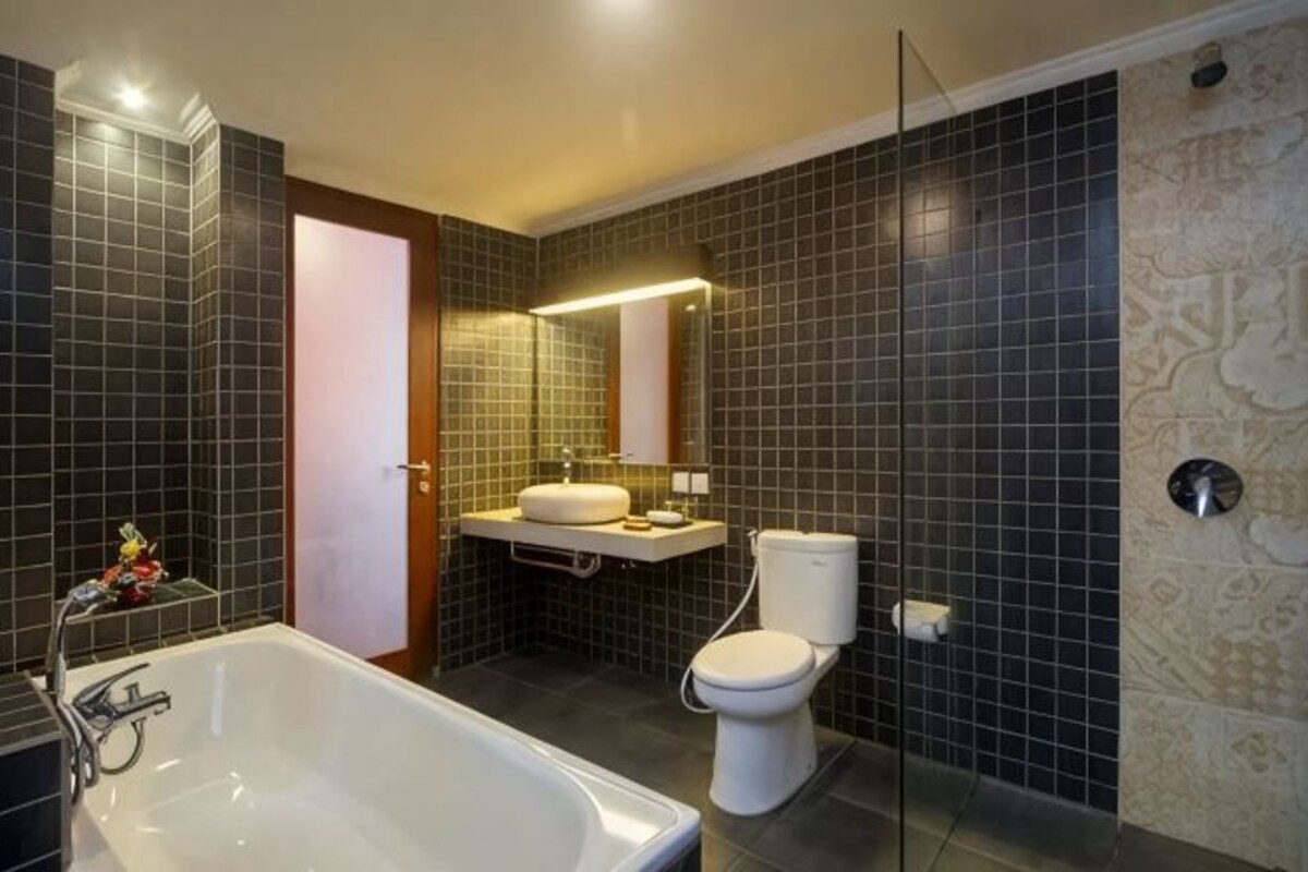 A modern bathroom with a bathtub, toilet, and sink.