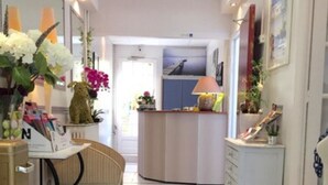 Une cuisine moderne dotée d’un îlot central, d’un coin repas avec une chaise et d’un comptoir avec une lampe.