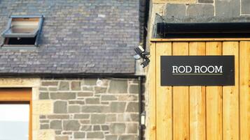 A wooden door labeled "ROD ROOM" with a stone wall and a window in the background.