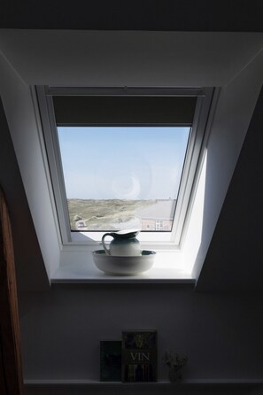 A skylight with a view of a building and a road. - Kellers Badehotel (Fano)