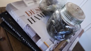 Eine Zeitschrift mit dem Text 'DESIGN HAM' und 'FRANKRIGS VINE OG VINDESTI', die auf einem Tisch liegt.