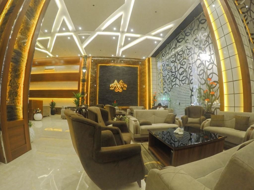 A modern lobby with a star-shaped ceiling design, plush seating, and a decorative wall with a logo.