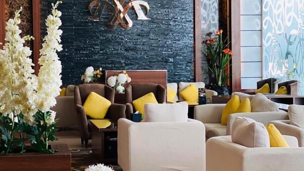 A modern living room with sofas, a coffee table, and floral arrangements. - Msharef Al Moden Suites (Abha)