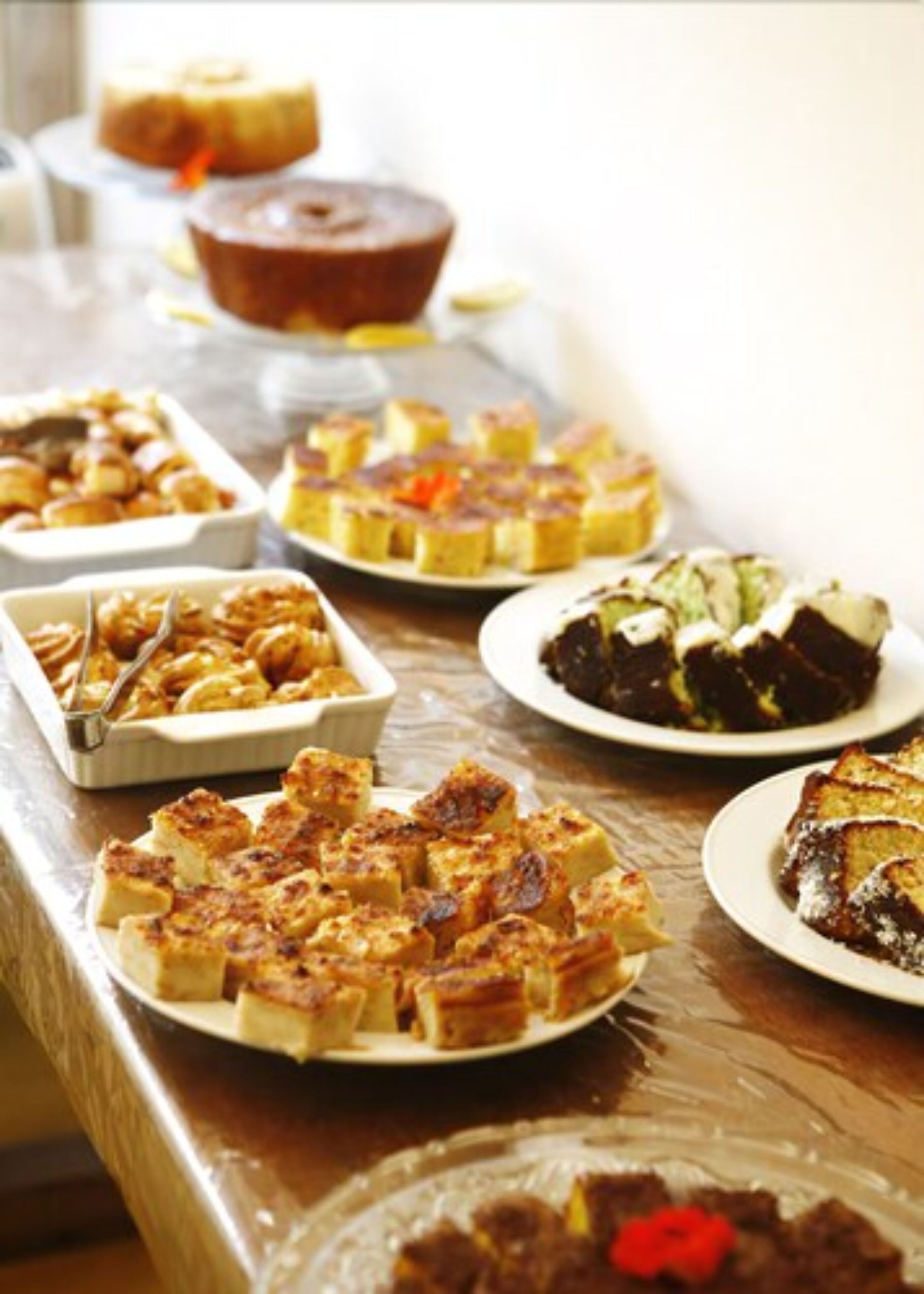 A buffet table with various dishes including a cake, a pie, and some bread.