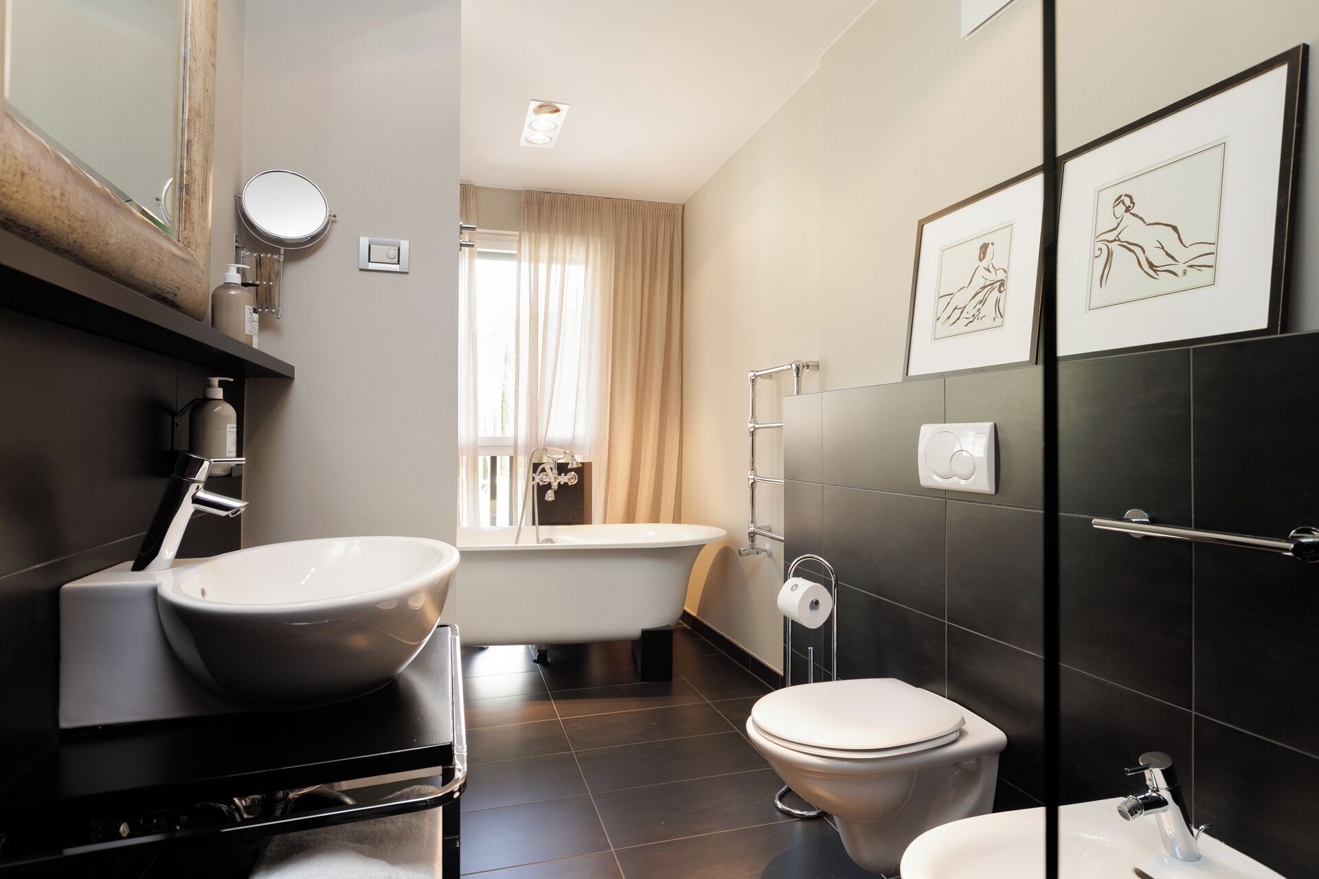 Un baño moderno con una bañera independiente, un inodoro y un lavabo.