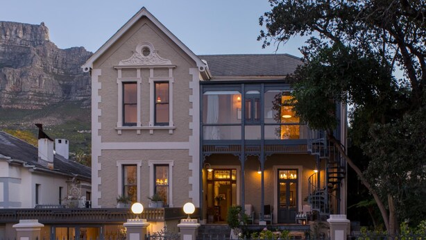 A two-story building with a balcony and a view of a mountain.