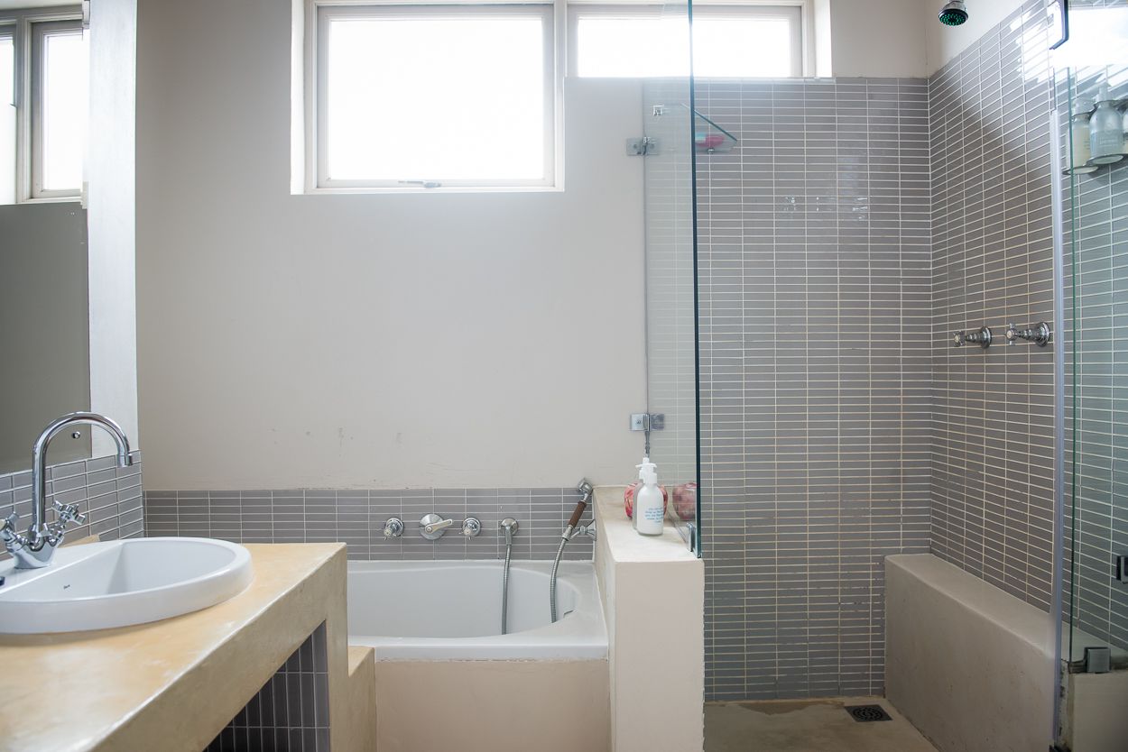 A modern bathroom with a bathtub, a sink, and a shower area.