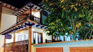 A two-story building with a balcony, a sign reading "Pousada Ramalho", and a large tree in front. - Pousada Ramalhete (Tiradentes)
