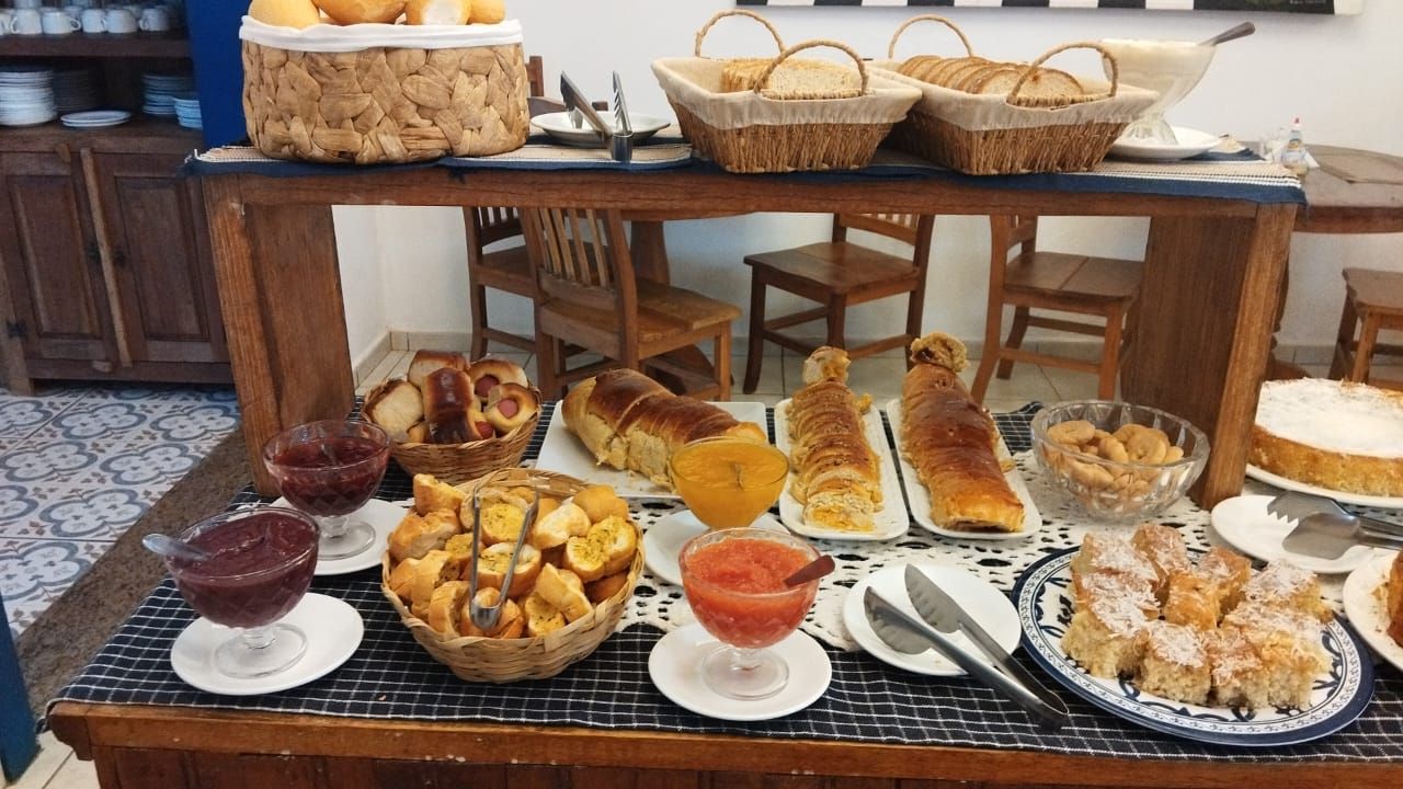A buffet table with various breads, pastries, and desserts.
