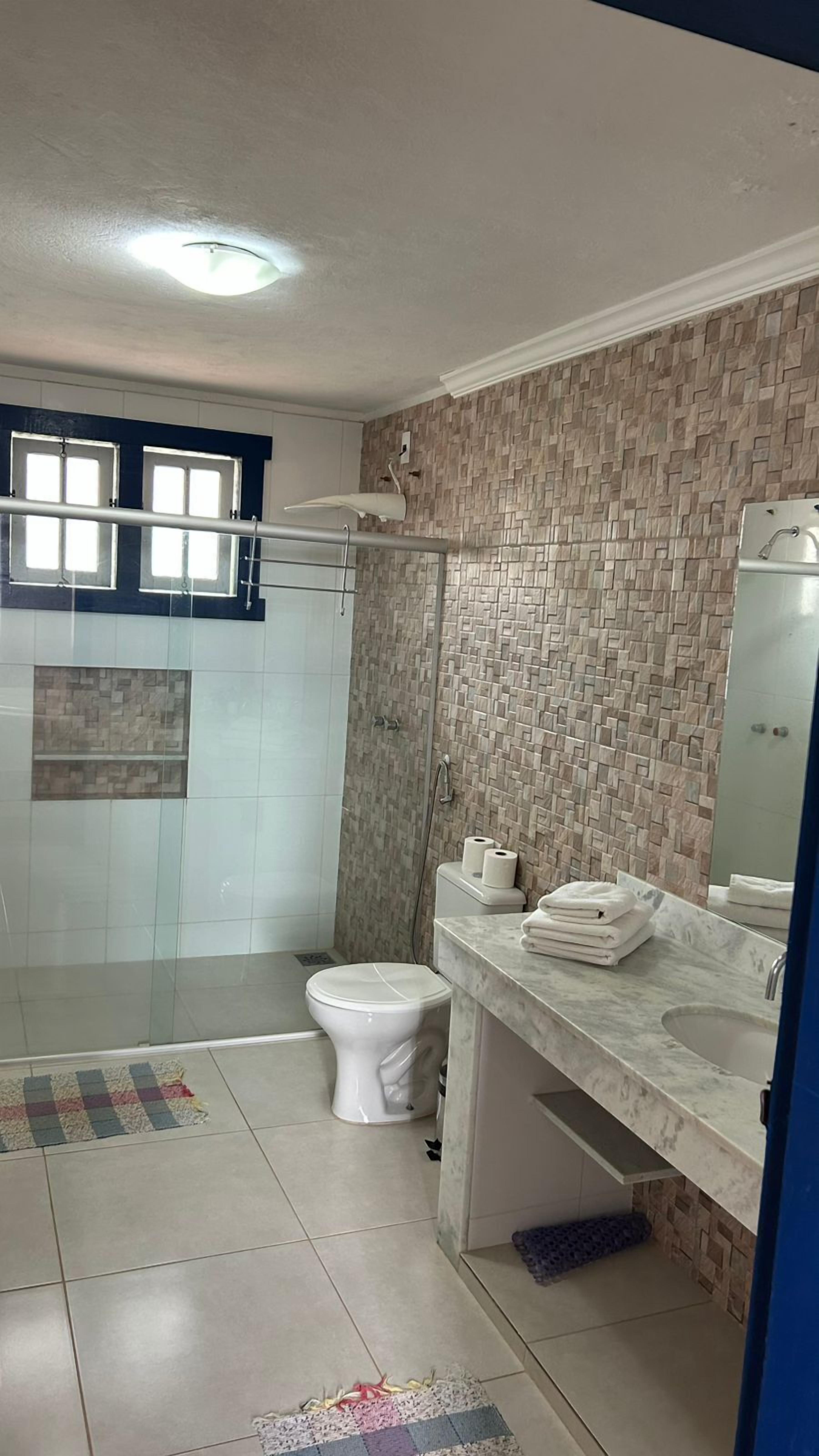 A bathroom with a shower, toilet, and sink.