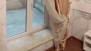 A room with a window, a curtain, and a wall with a floral pattern. - Apart Hotel Na Dobu (Lviv)