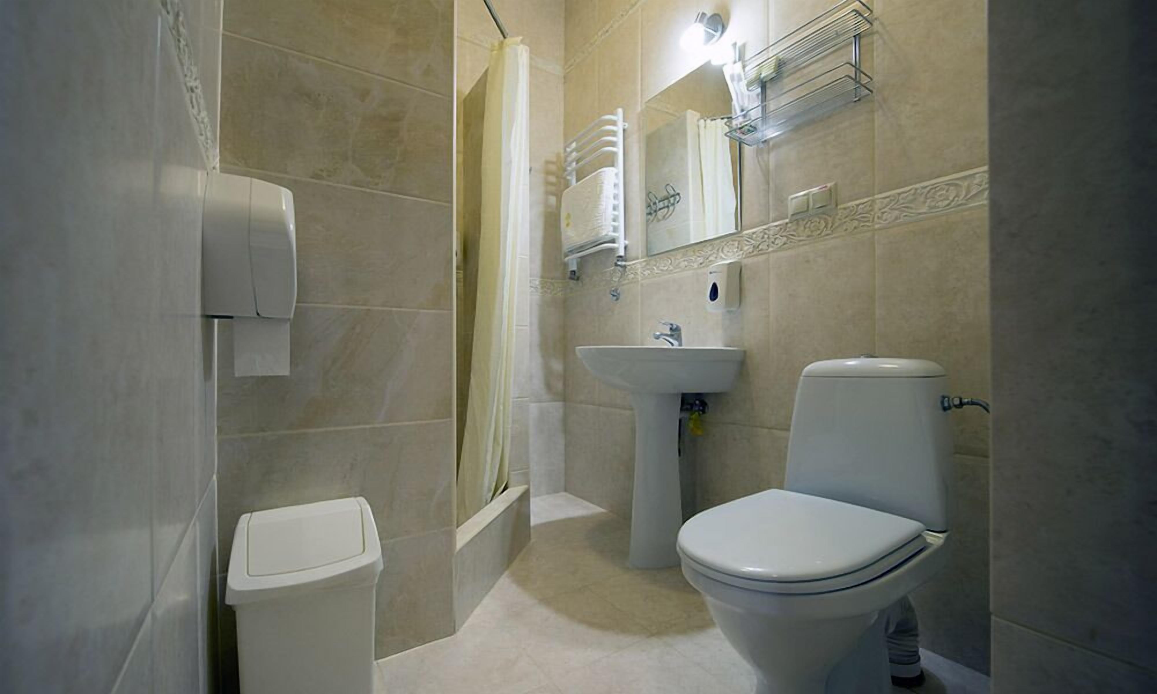 A bathroom with a toilet, sink, and shower.