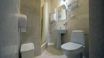 A bathroom with a toilet, sink, and shower.
