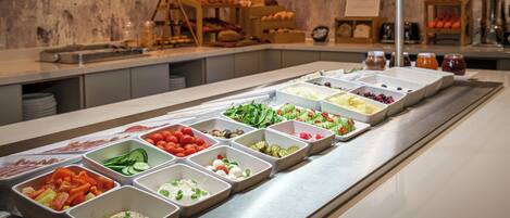 A buffet with various food items in trays.