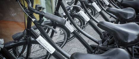 Varias bicicletas estacionadas en fila, con letreros adheridos.