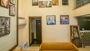 A lobby with a modern design, featuring a large sofa set, a coffee table, and a unique chandelier. - Tulsi Casa (Bhopal)
