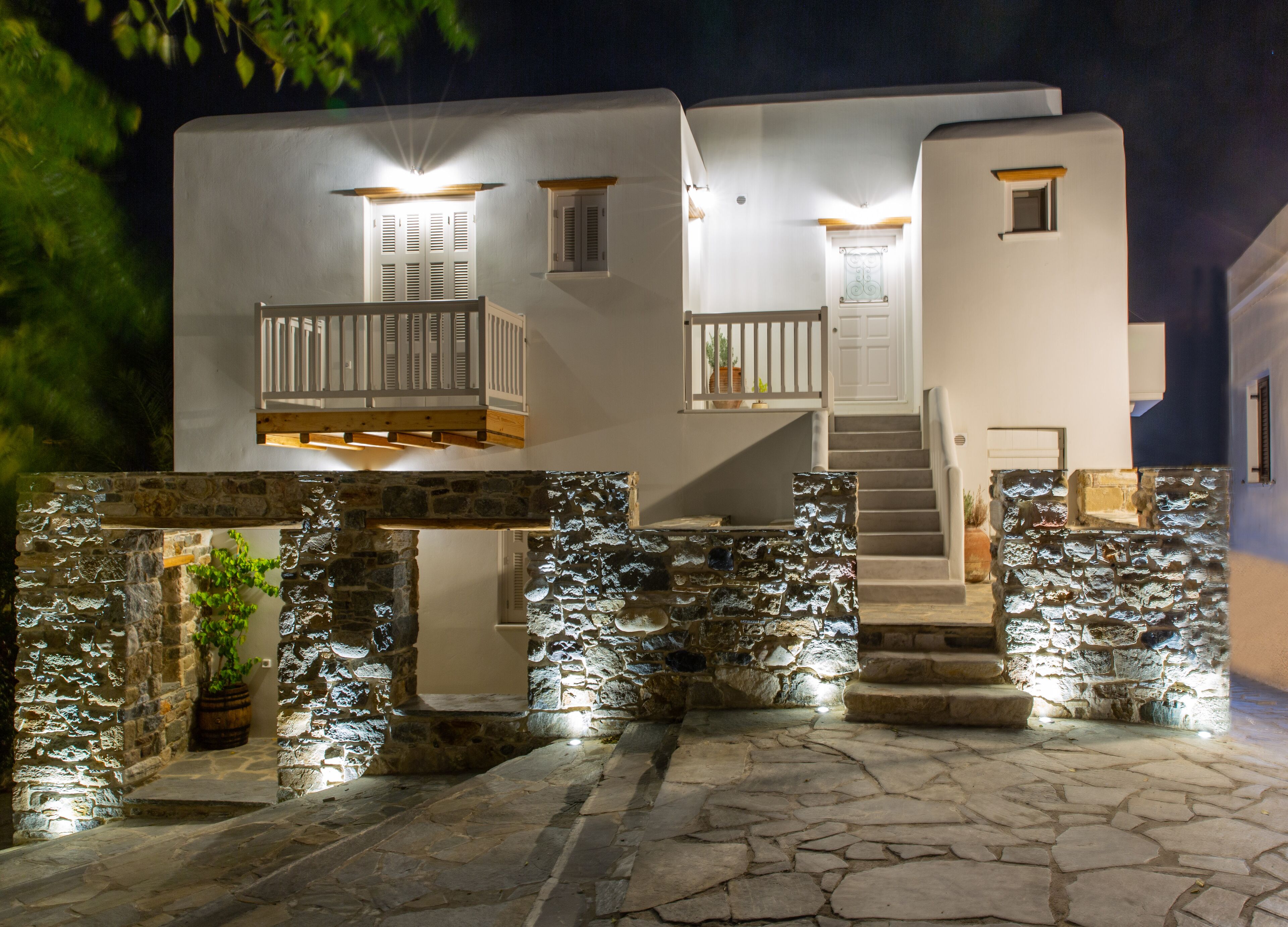 A two-story building with a stone facade, a wooden balcony, and a staircase leading to the upper floor.