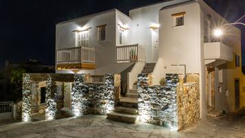 Un edificio moderno con fachada de piedra, varios balcones y una escalera que conduce a la entrada.